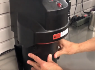 A man using the RADIA Auto Lid Press to seal a can of paint with a YouTube play button overlaid